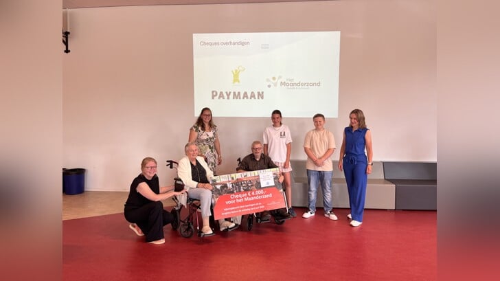 Bewoners van het Maanderzand ontvangen de cheque van twee brugklasleerlingen