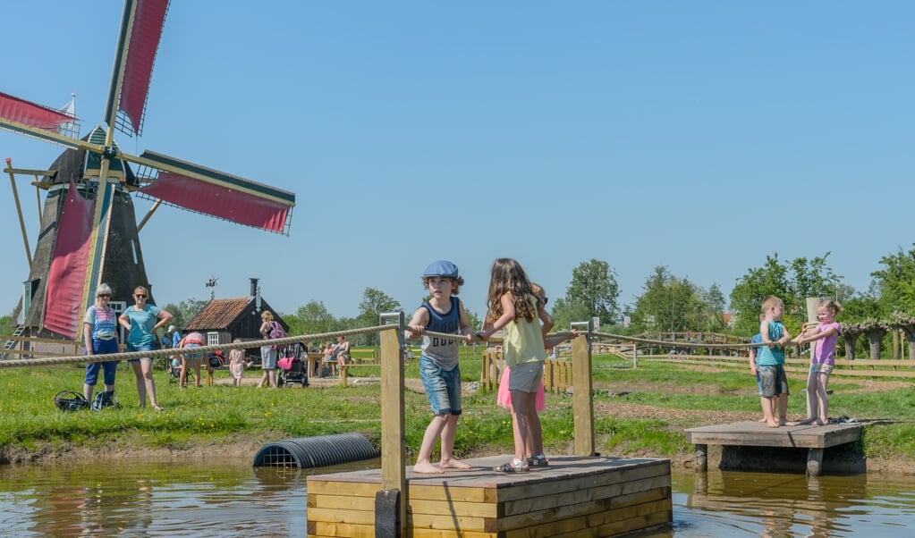 Met de trekpontjes kunnen de kinderen naar de overkant varen. Op de achtergrond de molen, waar een molenaar uitleg geeft. 