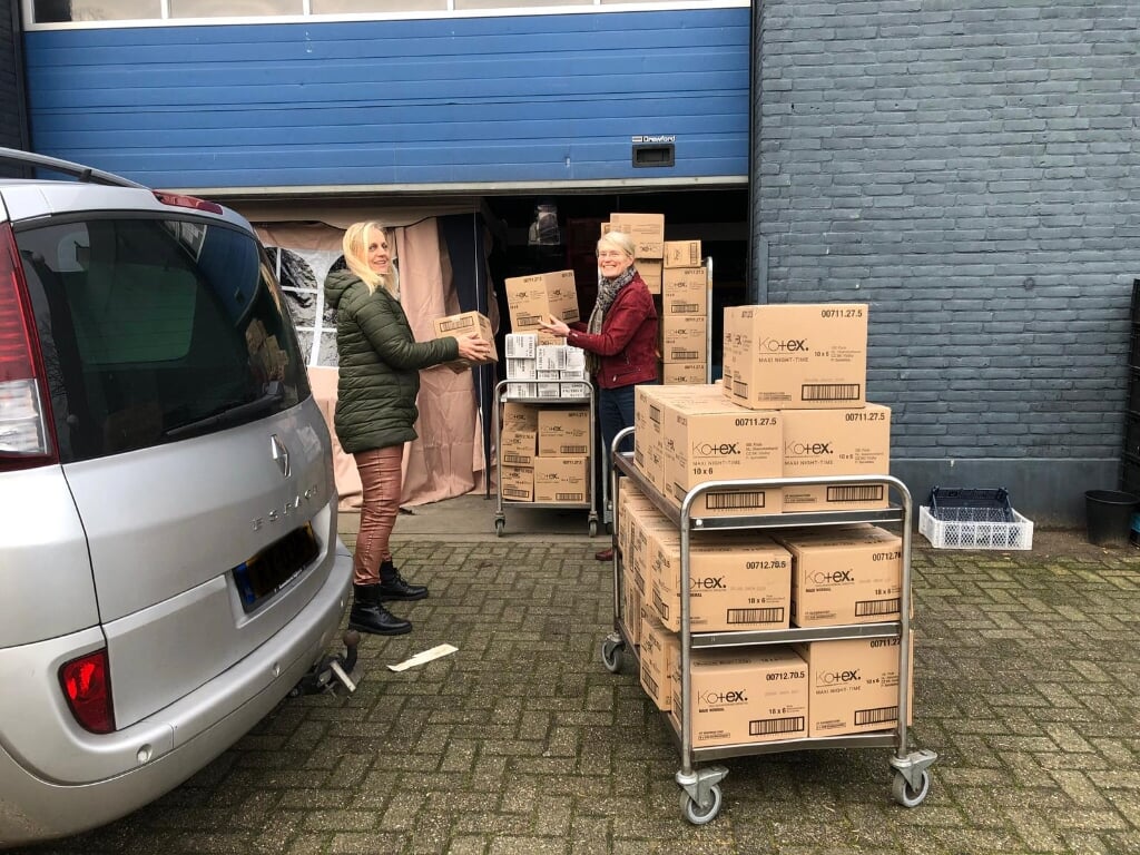 De dozen met Kotex worden overhandigd door Laura Feller aan Roos Hordijk van de Voedselbank Ede