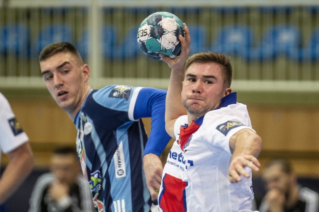 2021-02-06 20:31:23 epa08992581 Luc Steins (R) of PSG throws the ball next to Nik Henigman of Mol-Pick Szeged during men's handball Champions' League Group A 1st round match Mol-Pick Szeged vs Paris Saint-Germain in Szeged, Hungary, 06 February 2021.  EPA/Sandor Ujvari HUNGARY OUT