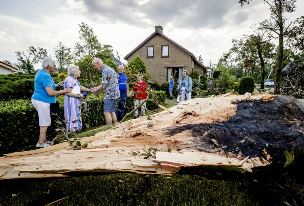 2021-06-18 18:34:48 LEERSUM - Een man helpt een vrouw bij een omgewaaide boom. In een groot deel van Nederland geldt code oranje wegens de kans op zware onweersbuien met kans op blikseminslag. ANP SEM VAN DER WAL