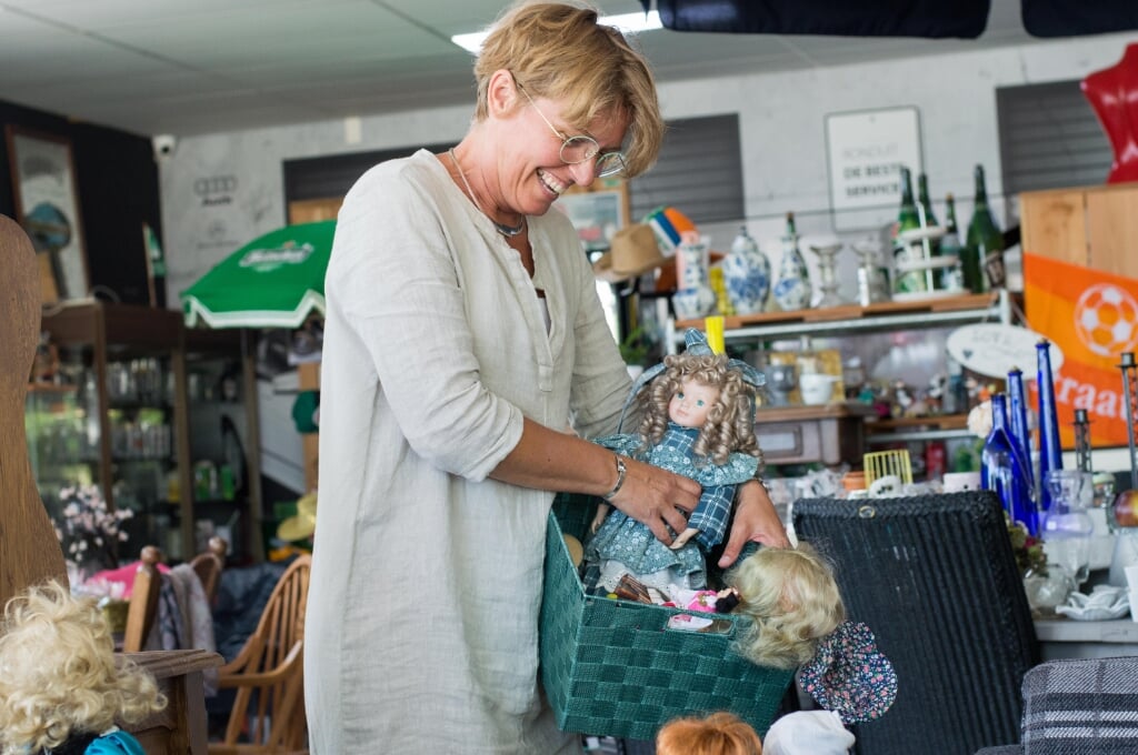 Zorgmedewerker Hennie Deij vult in kringloopwinkel Wullie Hen’ 't  een mand met poppen.