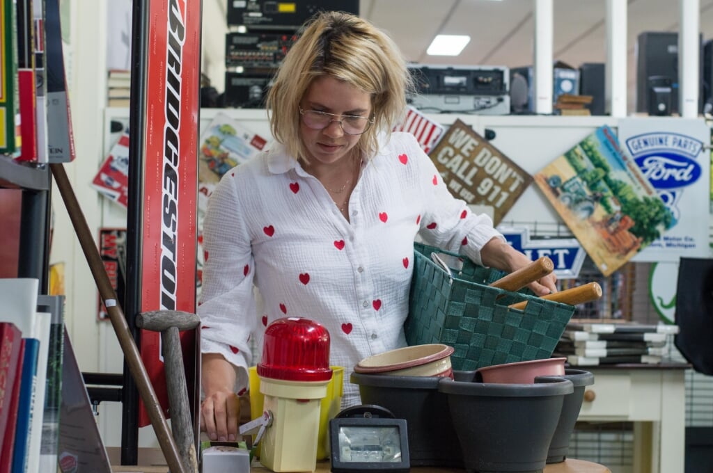 Zorgmedewerker Chantal Romijn vult in kringloopwinkel Wullie Hen’ 't een mand met keukenartikelen.  
