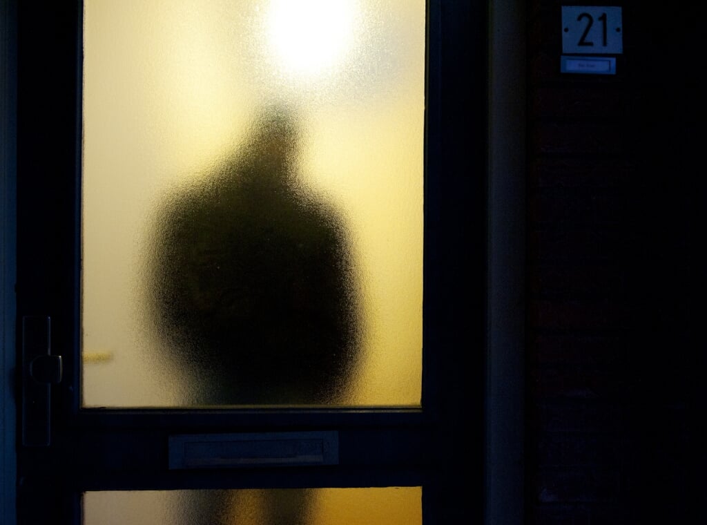 2012-05-30 00:00:00 ILLUSTRATIE - Een man achter het vensterglas van een voordeur. ANP XTRA ROOS KOOLE