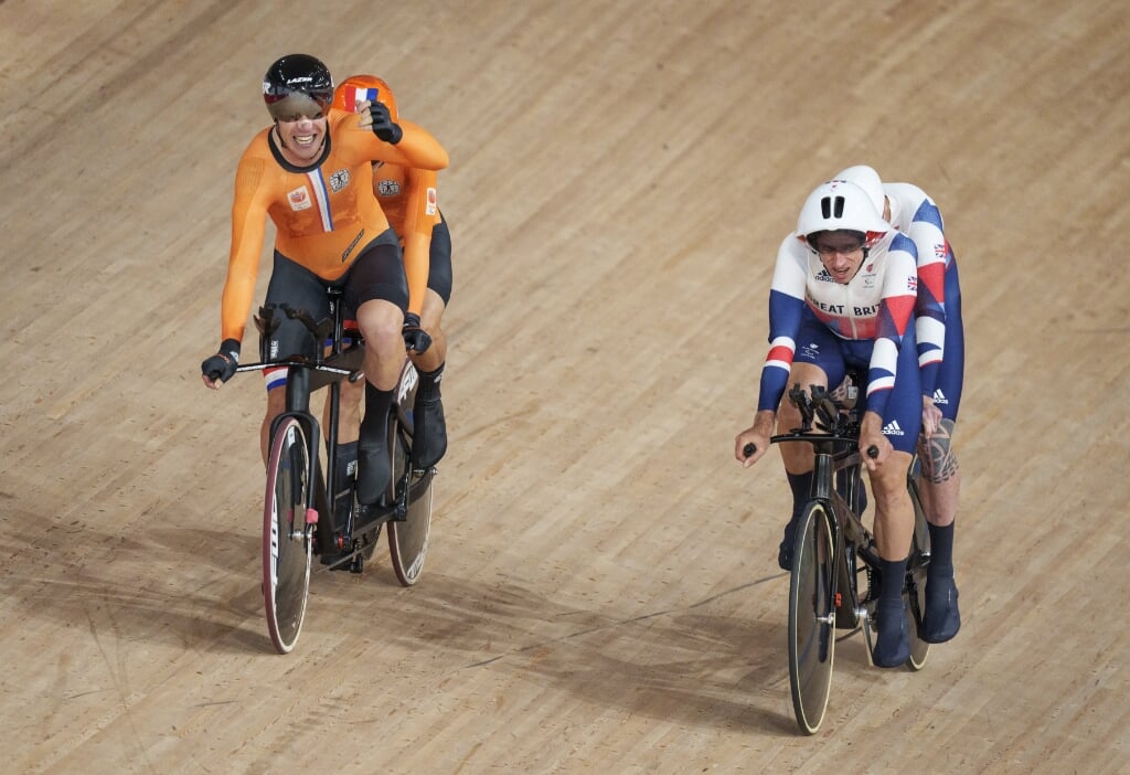 2021-08-25 15:04:40 epa09428437 Tristan Bangma of the Netherlands (L) with pilot Patrick Bos celebrates as they ride alongside Stephen Bate of Britain with pilot Adam Duggleby in the Track Cycling Men's B 4000m Individual Pursuit at the Izu Velodrome, during the Tokyo 2020 Paralympic Games, in Tokyo, Japan, 25 August 2021.  EPA/Thomas Lovelock for OIS  HANDOUT EDITORIAL USE ONLY/NO SALES