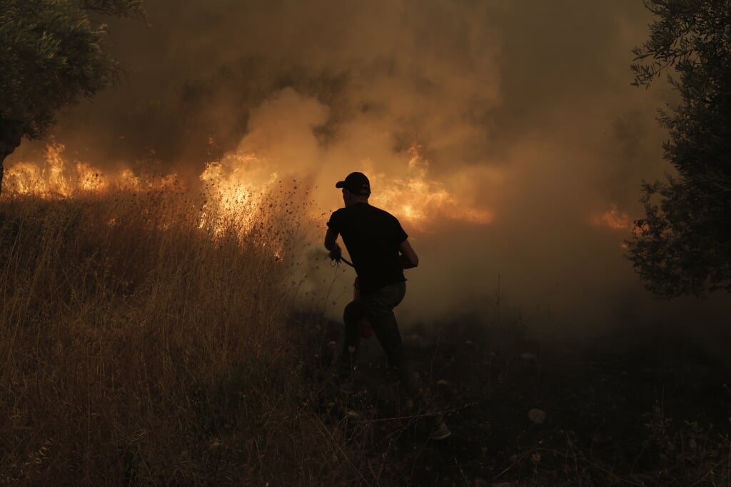 Een brandweerman vecht tegen de vuurzee op het Griekse eiland Evia.