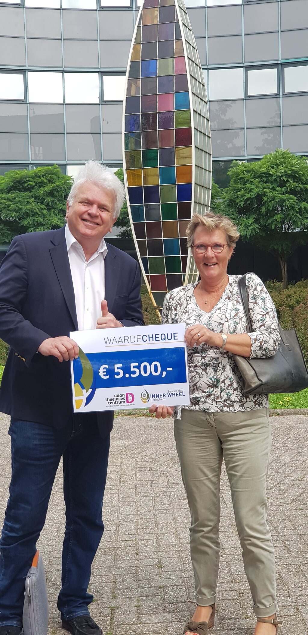 Marlene van Rooijen overhandigt de cheque aan Adriaan Theeuwes