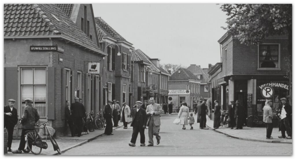 Op deze foto van de Nieuwstraat is in de verte de zijgevel van de zadelmakerij van J.M. van den Beld zichtbaar, met daarvoor het hek om de tuin van het oude huis van Van de Craats.