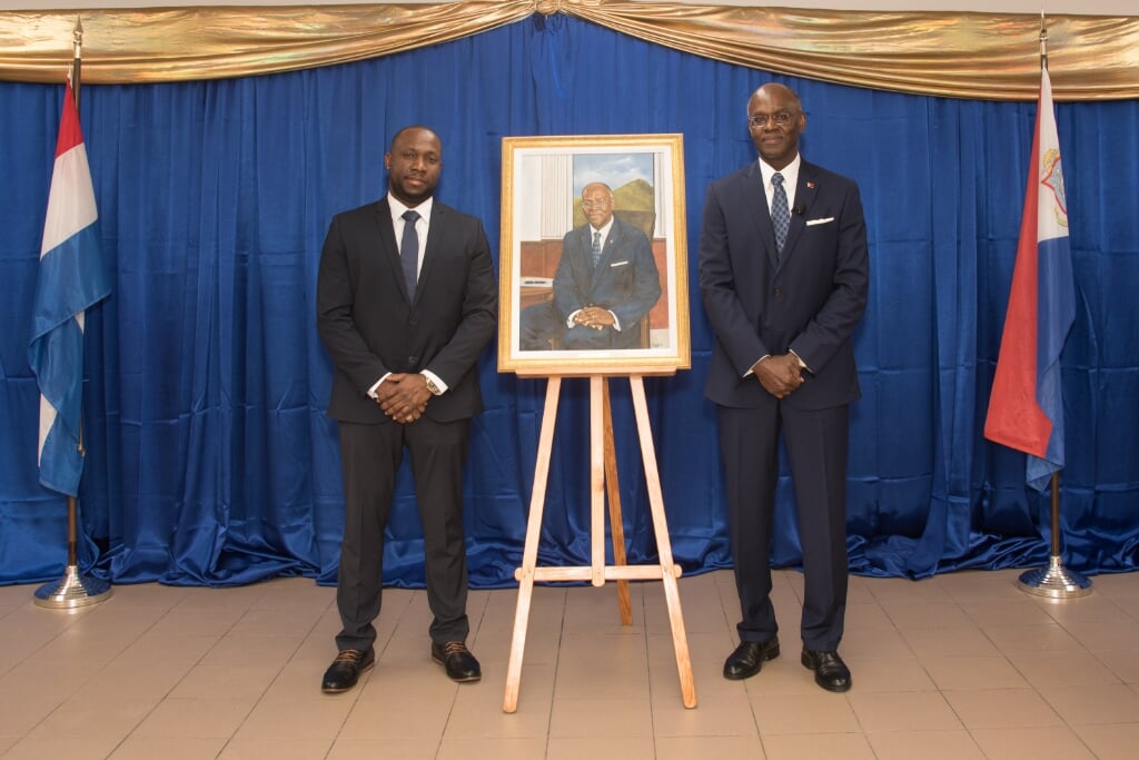 Alfredo Doornkamp (links) met gouverneur Eugene Holiday van St. Maarten en het geschilderde portret.