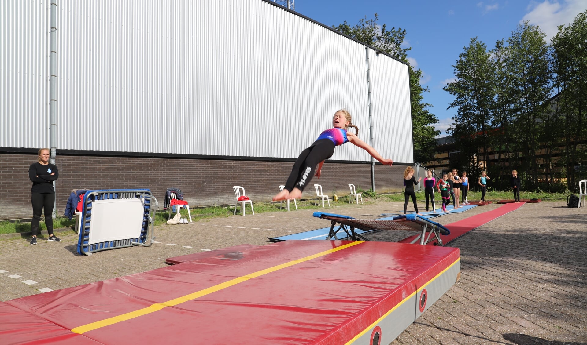 Stephanie Hofman kijkt toe hoe één van haar pupillen een sprong vanaf de trampoline maakt.