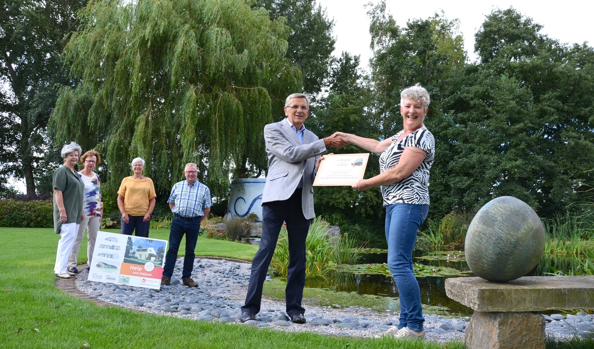 Anja Rietveld overhandigt in het bijzijn van tuinclubleden en een bestuurslid van het hospice de cheque aan voorzitter Rinus Bosman.