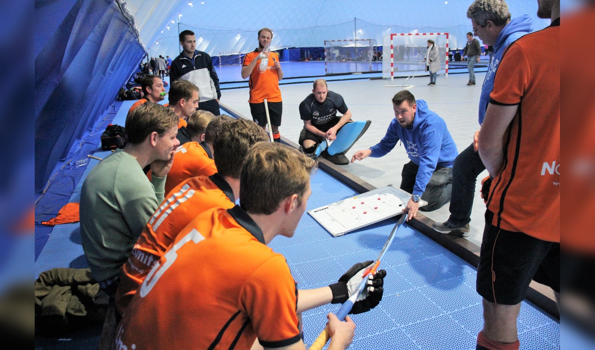 De spelers van De IJssel luisteren aandachtig naar de instructies van coach Mathieu de Jong. (archieffoto)