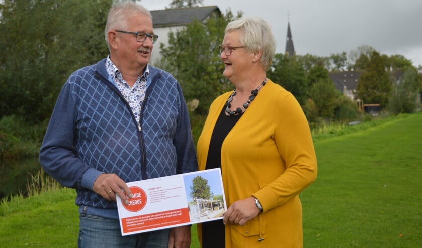 Hans en Elly van Dam in het Ringvaartpark, waar de dorskast werd bewonderd. Op de achtergrond de voormalige werkplek van Hans.