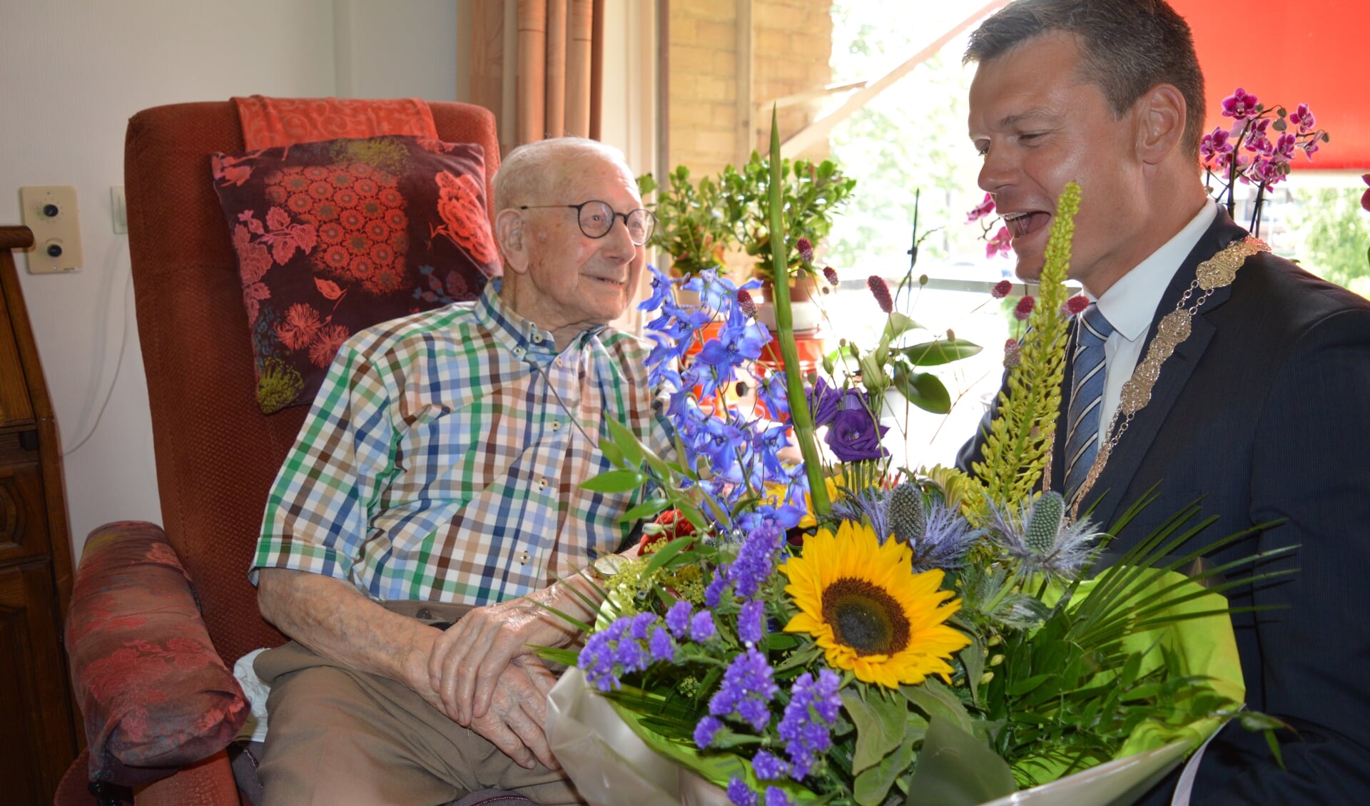 De 100-jarige Dirk van Rooijen kreeg van burgemeester Nieuwenhuis een bloemetje. (foto en tekst: Nicole Lamers)