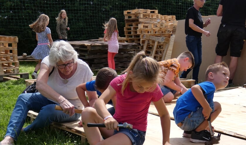 Oma helpt mee met het bouwen van een hut. (Foto en tekst: Annette van den Berg)