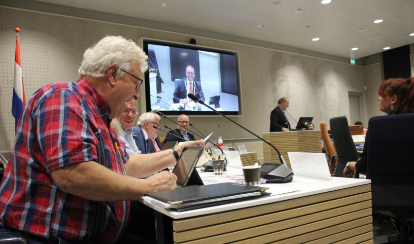 Raadslid Johan Helmer stoeit met zijn kaartje, terwijl burgemeester Servaas Stoop in vijfvoud lol heeft. (foto en tekst: Erik van Leeuwen)