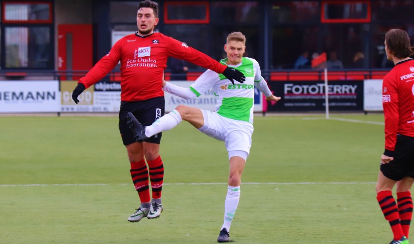 Nieuwerkerker Kevin Kamerbeek wint een duel van een speler van Spijkenisse.