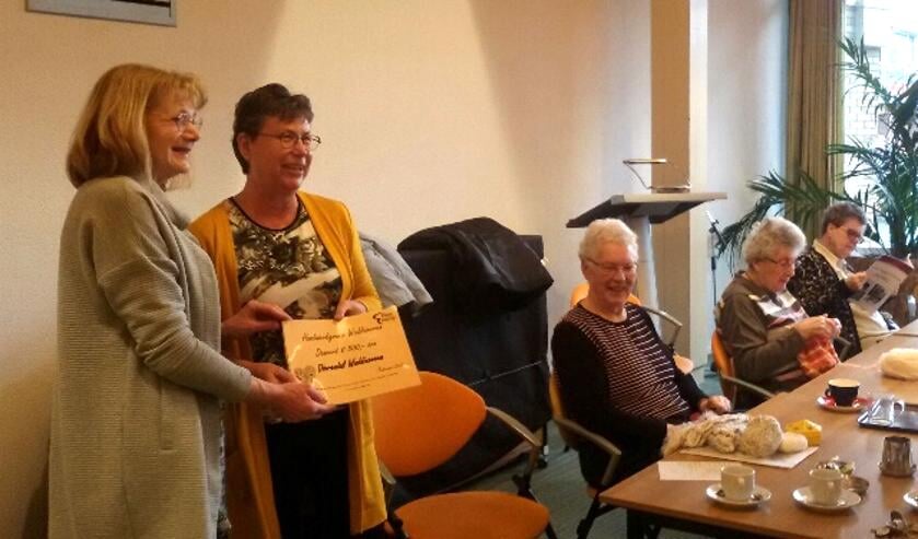 De dames handwerken rustig door als Ellen van Helden de cheque in ontvangst neemt. (foto: pr)