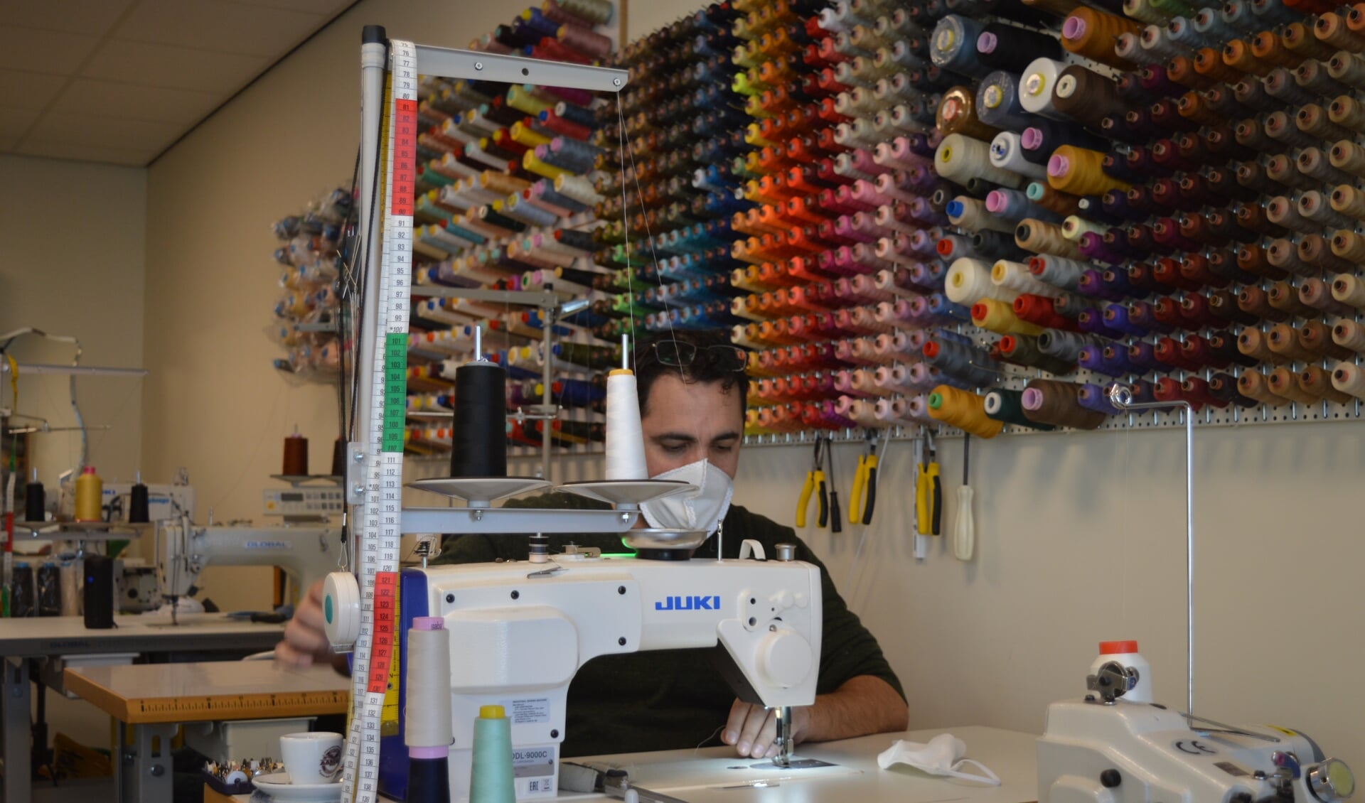 Yanni Azami brengt een van zijn naaimachines in gereedheid.
