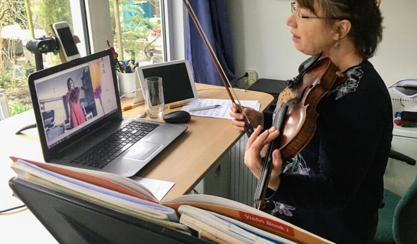 Viooldocent Monique van Leeuwen via het internet aan het werk met een leerling.