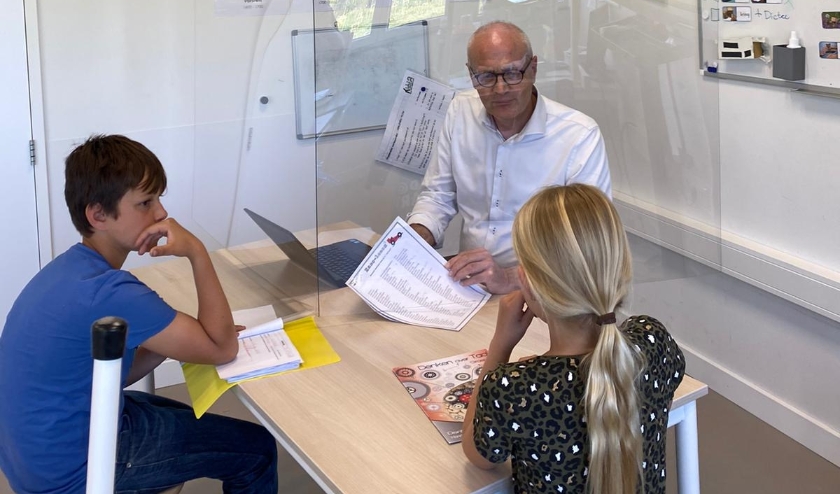 Op de PWA-school is een halve plexiglascabine gemaakt zodat individuele hulp altijd mogelijk is.