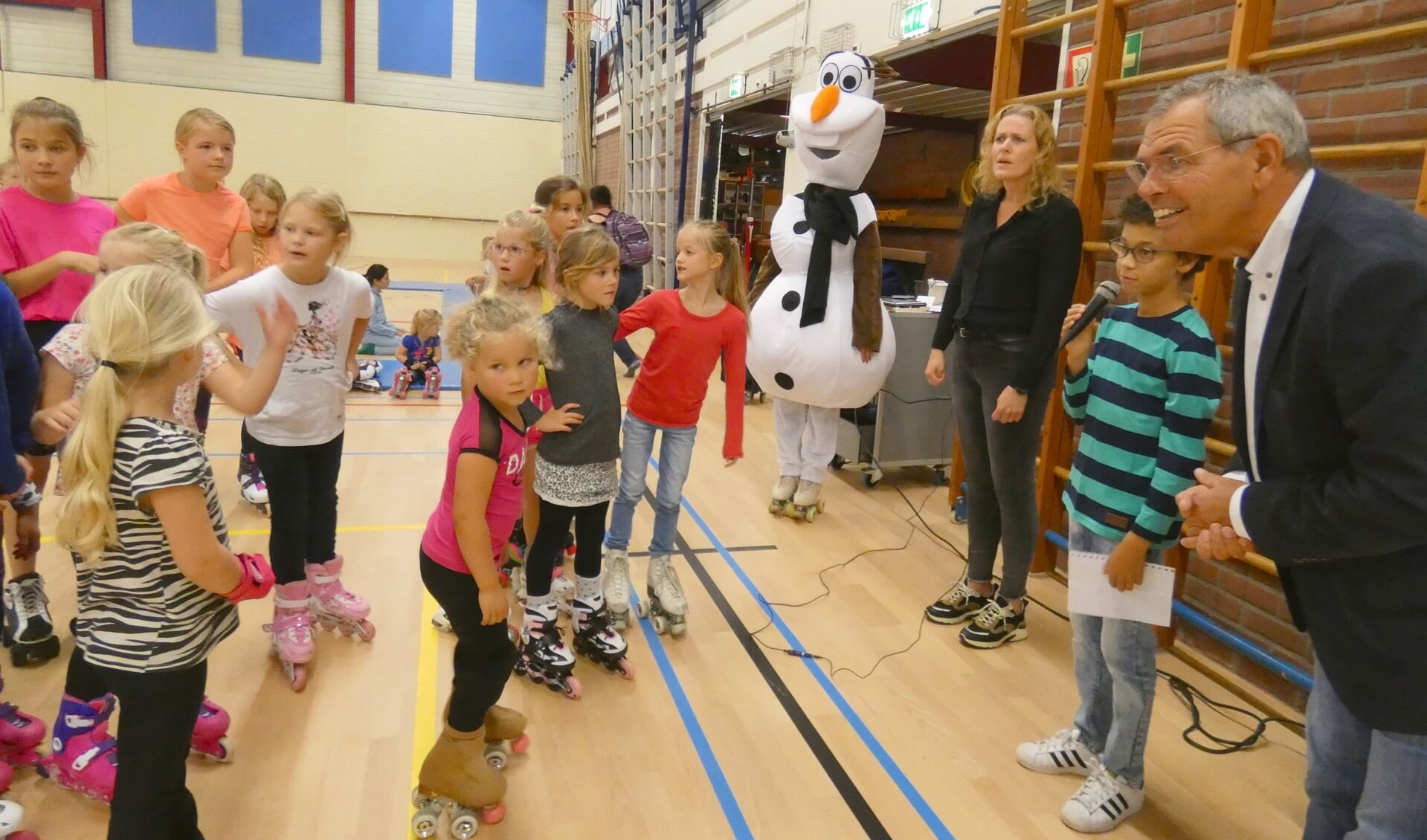 Wethouder Jan Verbeek en kinderburgemeester Faris el Achrafi bij de rolschaatsclinic in Op Moer.