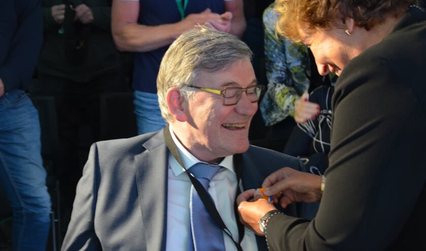 <p>Burgemeester Spies hangt de versierselen bij Gert Bruijnes om.</p>