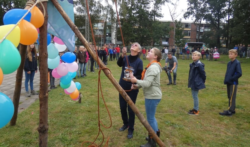 <p>Elly van der Heijden en kabouter Fleur ‘t Schroots hijsen de vlag.</p>