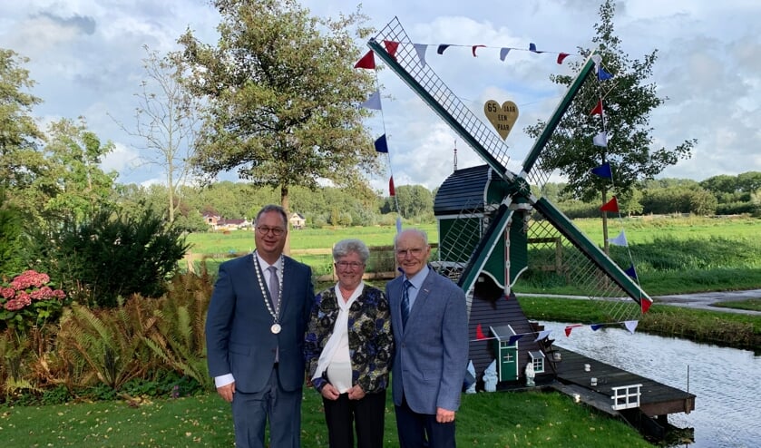 <p>Het echtpaar met de burgemeester bij de door Giel gemaakte molen in de tuin.</p>