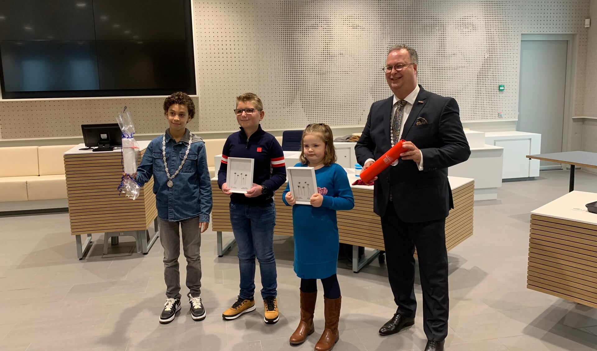 De awardwinnaars tussen de twee burgemeesters in de Nieuwerkerkse raadzaal.