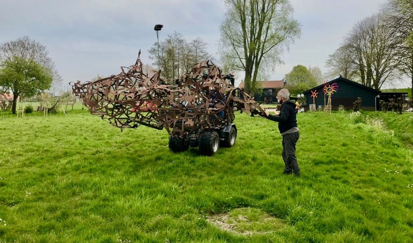 <p>Organisator Bart Belonje ‘dirigeert’ een groot werk van Gjalt Blaauw naar zijn plek in de Beeldentuin.</p>