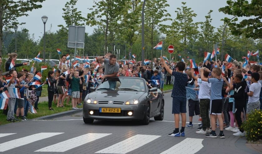 <p>Schooldirecteur Jeroen van Kouwen wordt rondgereden in een cabrio, tot groot plezier van veel kinderen. </p>