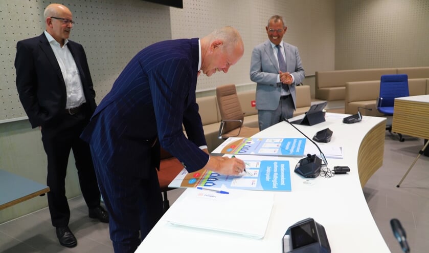 <p>Wethouders Jan Hordijk en Jan Verbeek zetten hun handtekeningen. (foto en tekst: Erik van Leeuwen)</p>