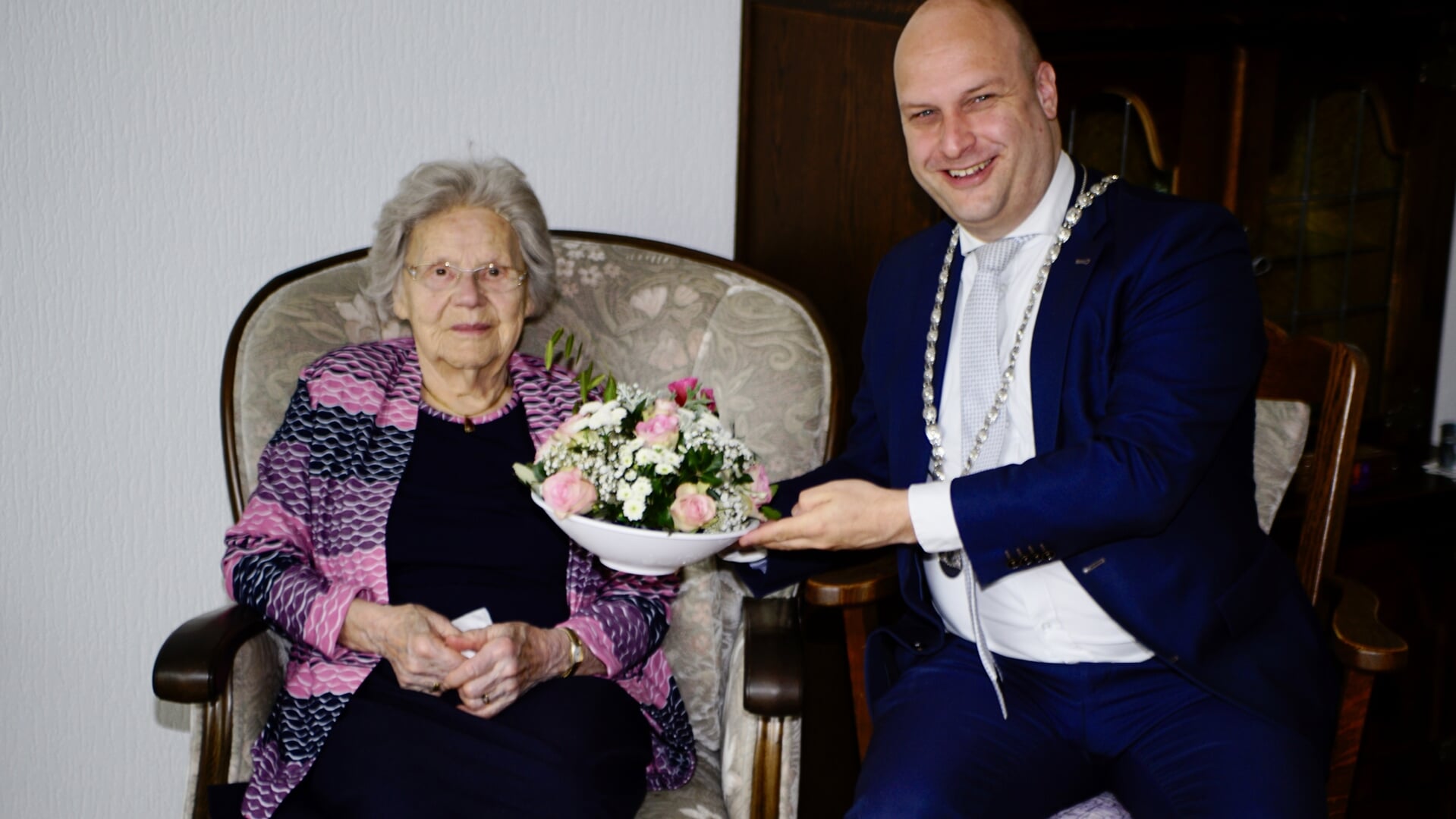 De 101-jarige Plonia van Tienhoven-Van der Spek ontvangt bloemen van locoburgemeester Schuurman.