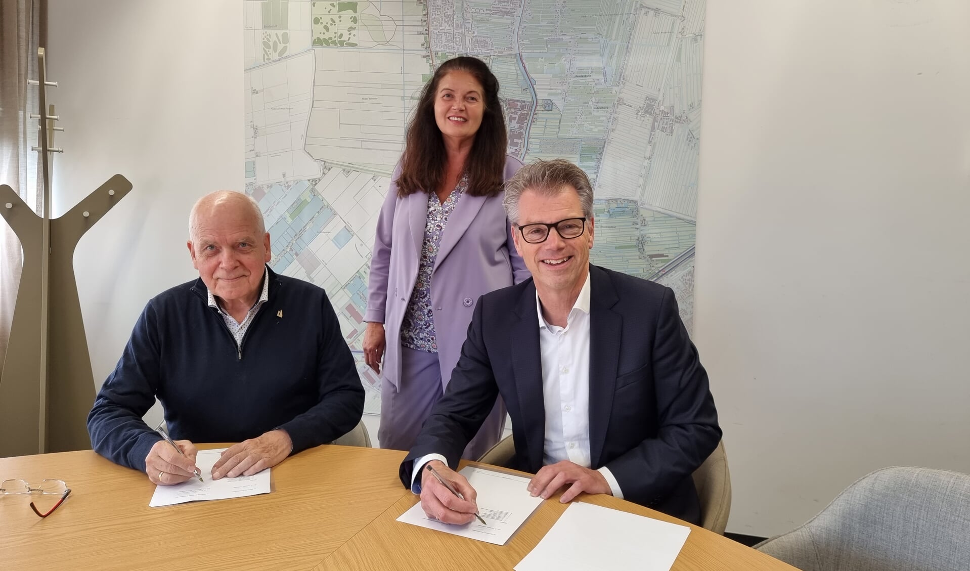 Wethouder Albert Kerssies (rechts) en de penningmeester van de Stichting Rotondes Waddinxveen Thon Bostelaar tekenen de overeenkomst in het bijzijn van Suzanne Hetyey van Care for Family.