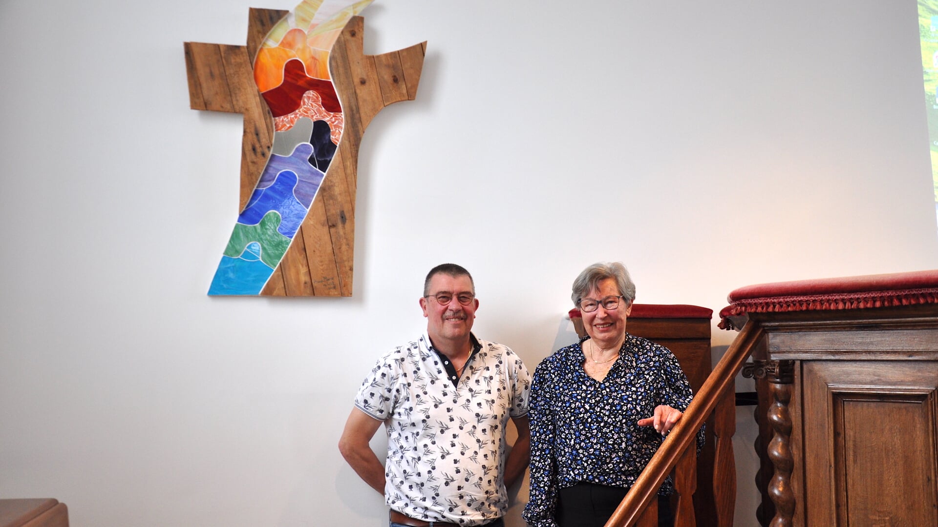 Albert Rook en Tineke Everaart bij het kruis in hun kerk. 