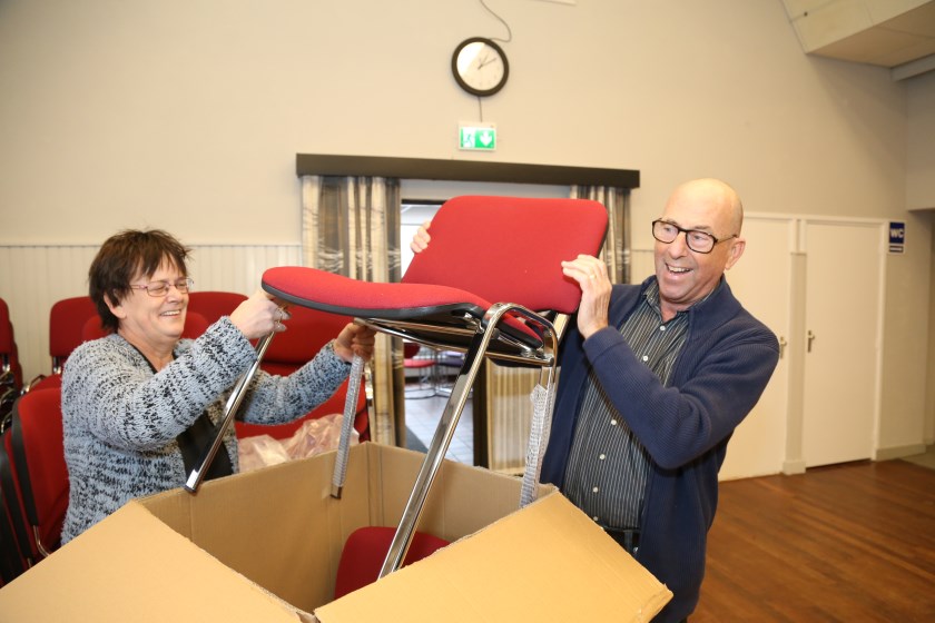 Beheerder Rian Eijkmans en voorzitter Michel Geilfus van De Orion pakken enkele van de 152 nieuwe stoelen uit. (Foto: Sander van Kasteren)