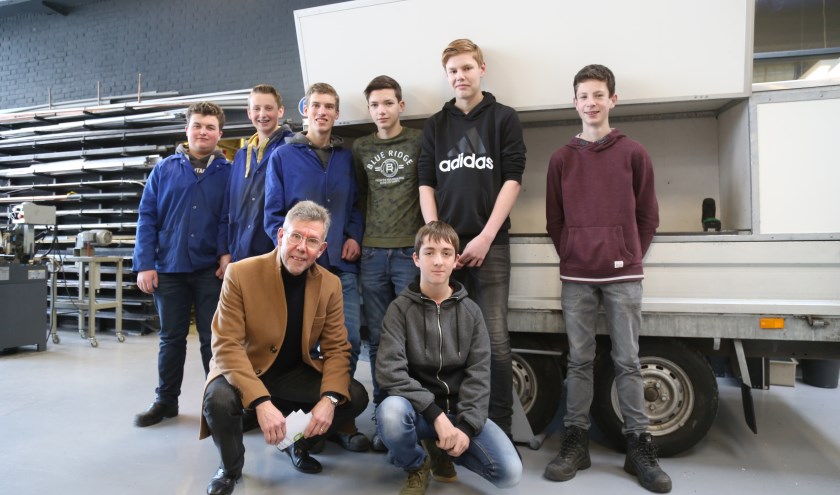 Van links naar rechts boven: BHC-leerlingen Bart, Ymre, Thomas, Lars, Stijn, Mark en rechtsonder Thijs biede IVN Best voorzitter Jan Ackermans (linksonder) hun zelfgemaakte aanhanger aan. | Fotonummer: 36aa46