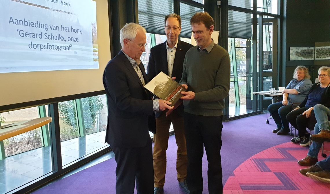 Gerard Schalkx (l.) met het eerste exemplaar van 'zijn' fotoboek, samen met wethouder Peter van de Wiel (r.) en Erfgoedvereniging Kék Liemt voorzitter Arnold van den Broek.