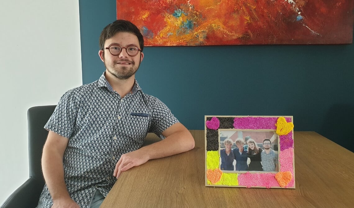 <p>Nando, met op tafel een foto van hem samen met de drie andere hoofdrolspelers.</p>