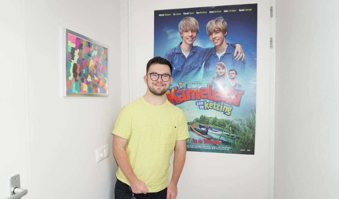 <p>Nando, vóór de Kameleon-poster in zijn appartement. (Foto: Sander van Kasteren)</p>