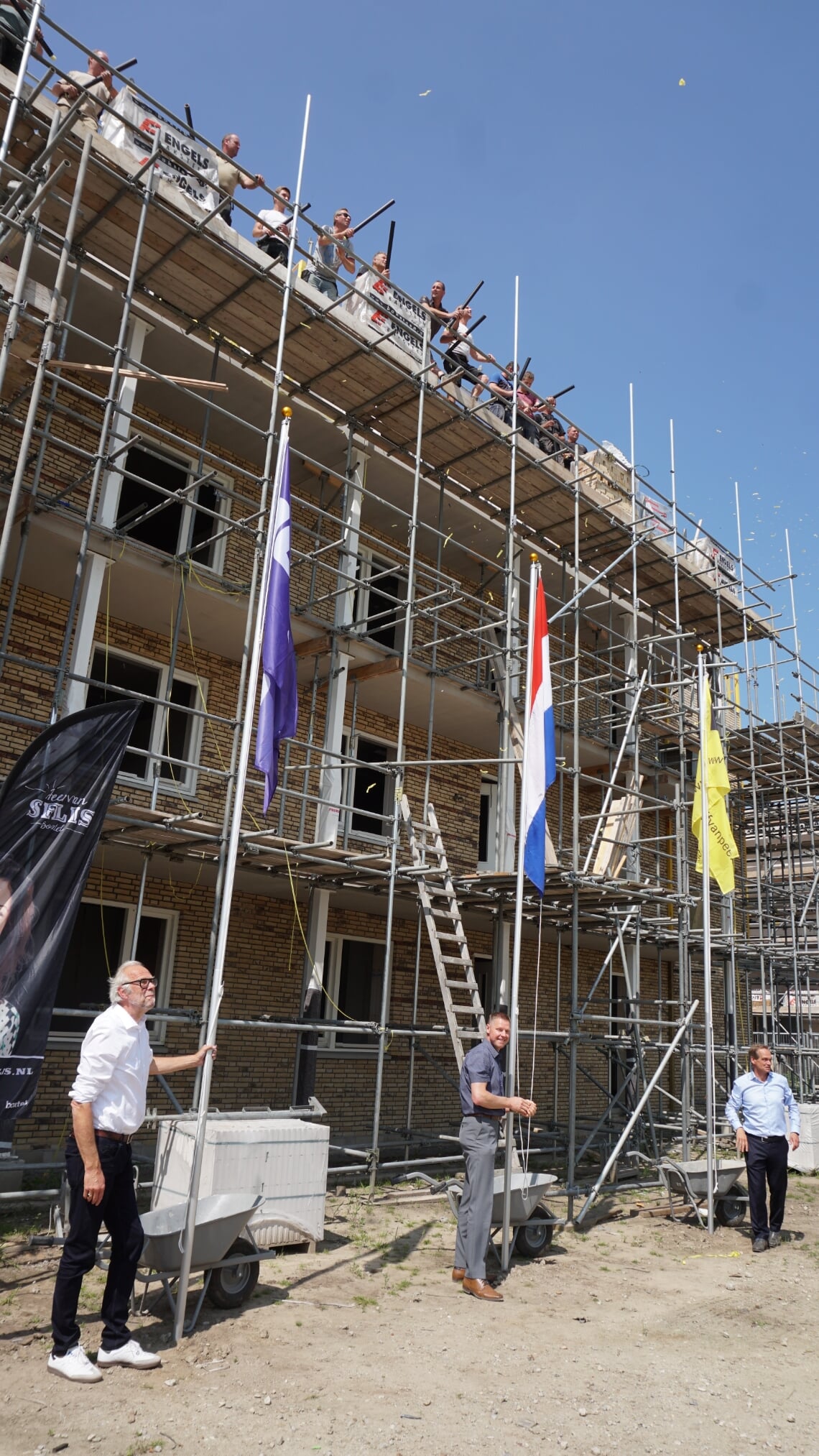 Wethouder Wim van der Zanden (m.) hijst samen met directeur-bestuurder Rob Dekker van Woonstichting JOOST (l.) en Jan van Peer van Bouwbedrijf Van Peer de vlag bij het nieuwe appartementencomplex.