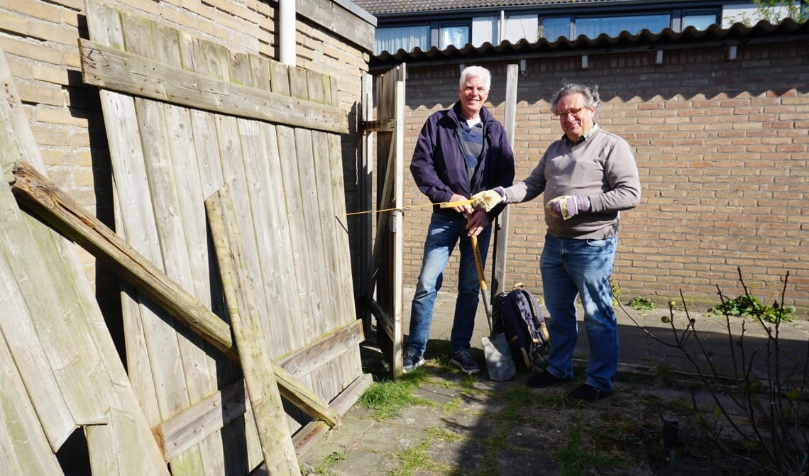 <p>Marc Hoyng (l.) Matthias Rauterberg zijn bezig met het repareren van een ingestorte schutting. (Foto: Sander van Kasteren)</p>