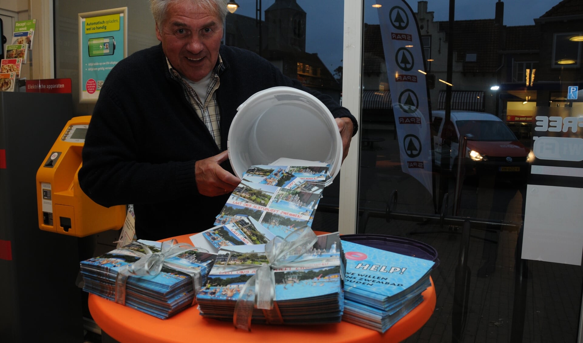 Piet Groffen schudt de emmer met kaarten leeg bij de Spar in Sint-Maartensdijk.
