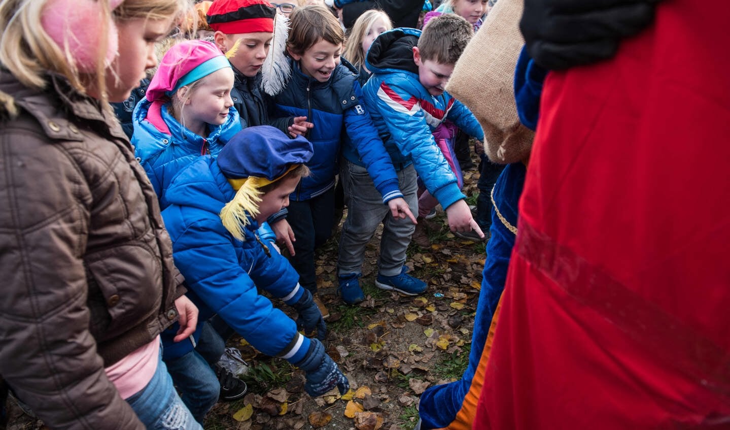 Kinderen ontdekken voeten onder het grote cadeau voor Sinterklaas.