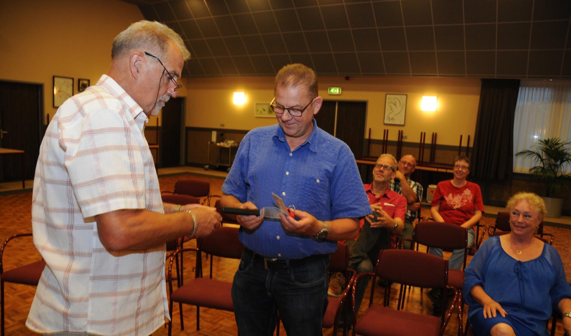 Paul van Rijswijk (rechts) krijgt van Henk van Driel van EHBO-vereniging Tholen een zilveren speld voor zijn 25-jarig jubileum. 