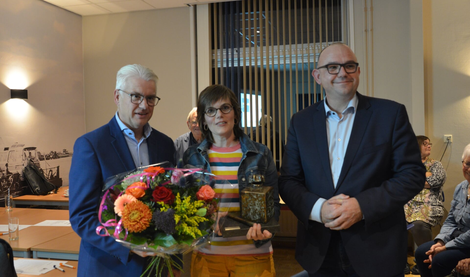 Louise van Gorsel kreeg de wisseltrofee uit handen van wethouder Frank Hommel. Rechts staat presentator Jaap Hage.