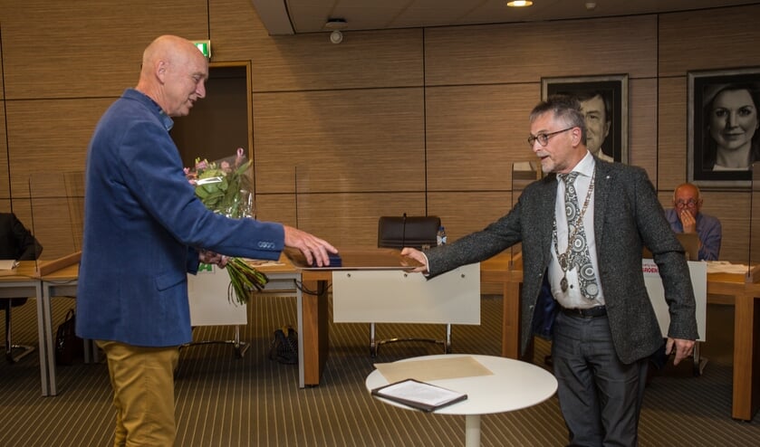 Rob Duijm ontvangt de erepenning van Henk Geluk. Geluk verving burgemeester Ger van de Velde als raadsvoorzitter.