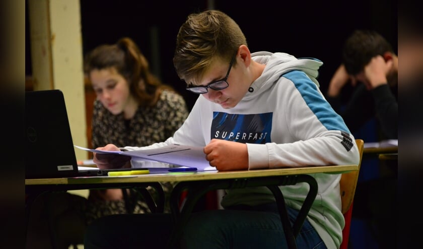<p>Niels Krijger werkt aan zijn eindexamen Nederlands in de gymzaal van het Calvijn College in Tholen.</p>