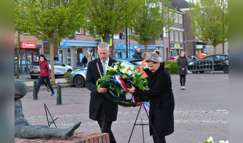Burgemeester en mevrouw Van den Belt leggen een krans bij het monument op het Raadhuisplein.
